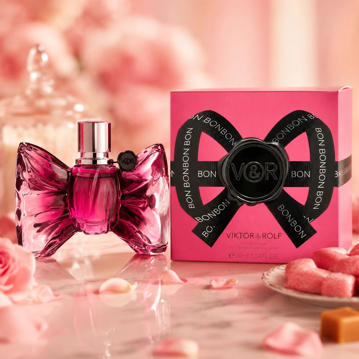 Viktor & Rolf Bonbon EDP 90ml for women hero image with the original pink bow-shaped bottle and pink box styled in a luxurious pink dessert-inspired setting with rose petals and sweet accents.