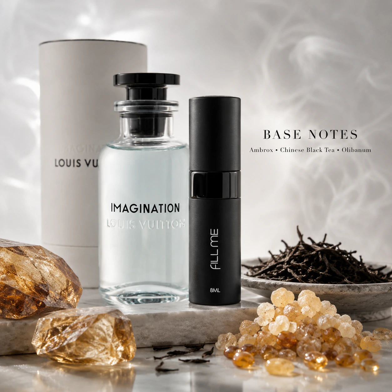 Louis Vuitton Imagination decant base notes image with ambrox, Chinese black tea, and olibanum beside the 8ml Fill Me atomiser.