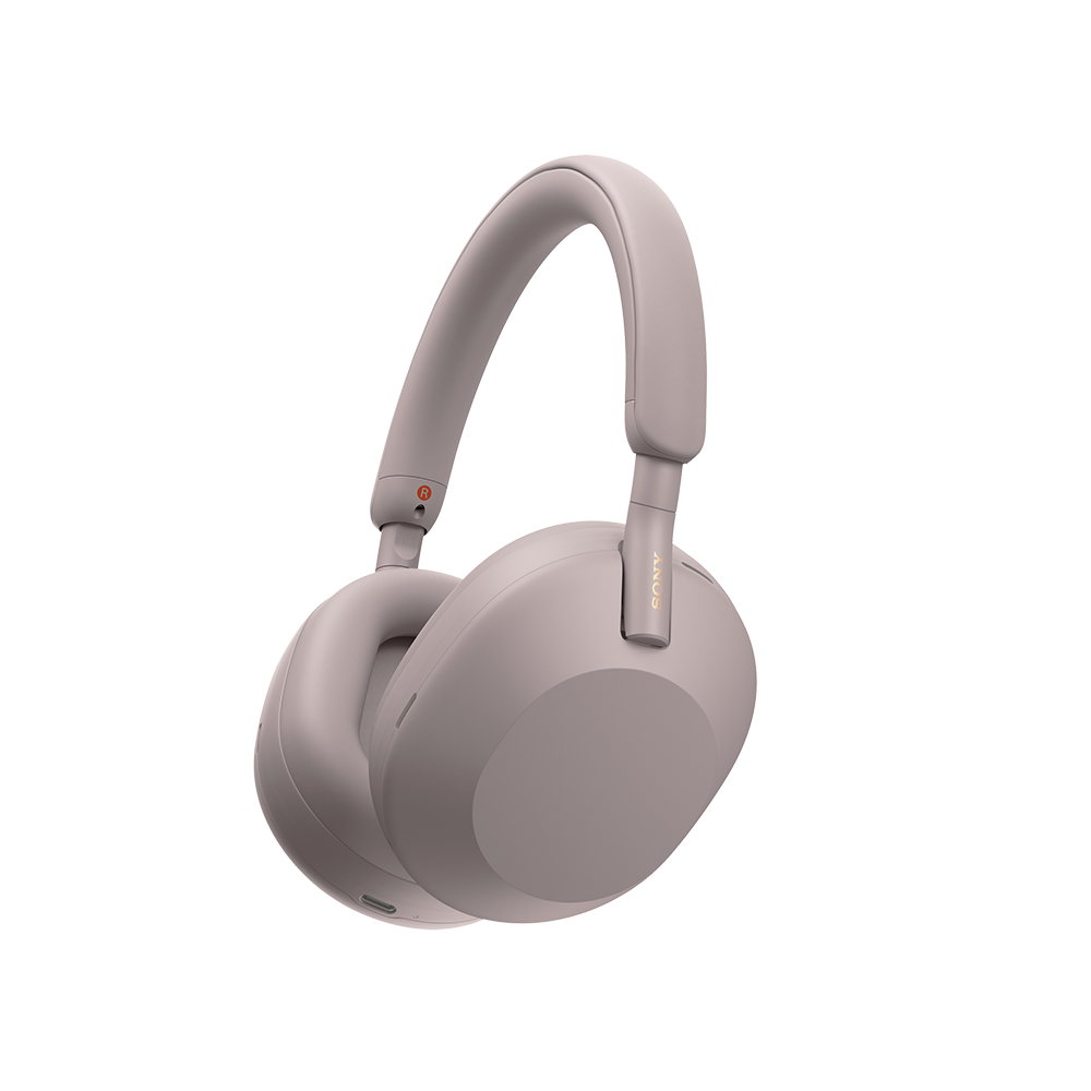 Pink Sony WH-1000XM5 wireless over-ear headphones on a person, highlighting the sleek, lightweight design and soft earpads.