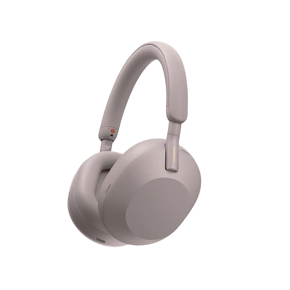 Pink Sony WH-1000XM5 wireless over-ear headphones on a person, highlighting the sleek, lightweight design and soft earpads.
