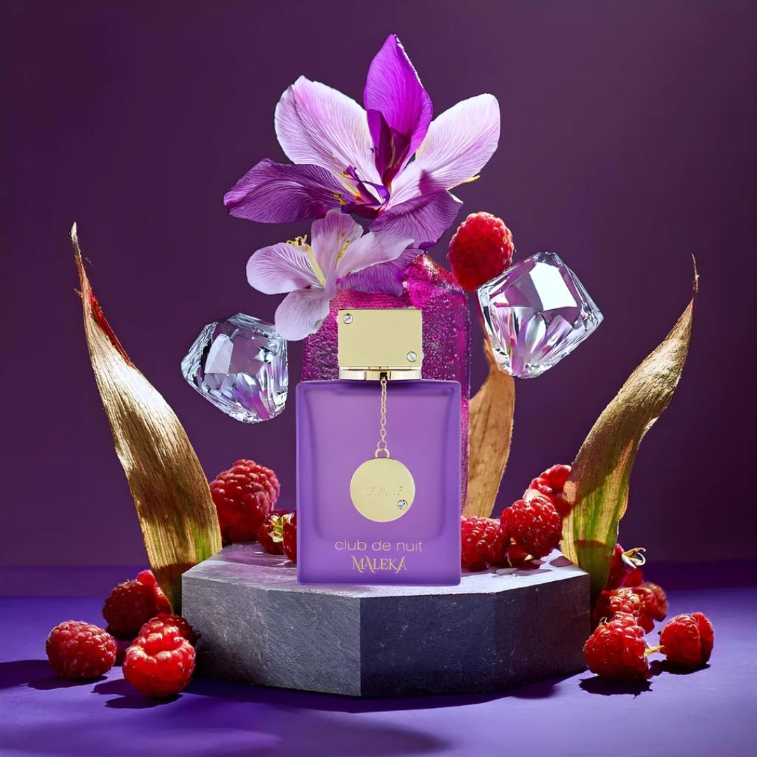 Purple perfume bottle with flowers and berries on a purple background