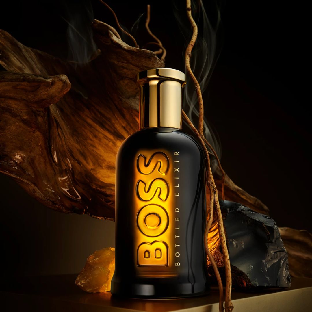 BOSS Bottle Elixir perfume bottle with gold cap on a dark background