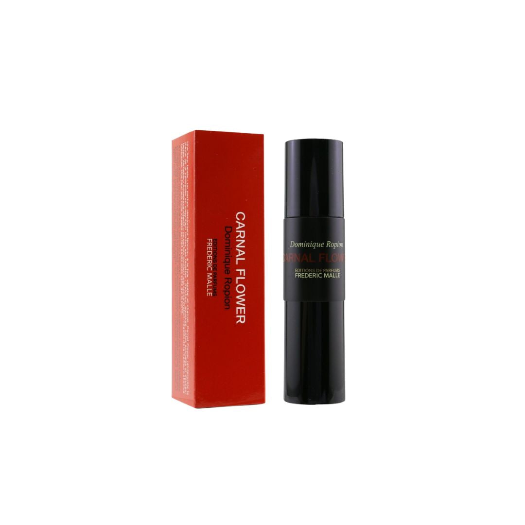 A black cylindrical perfume bottle next to its red rectangular box, labeled 'Carnal Flower 30ml' and 'Dominique Ropion', on a plain white background.