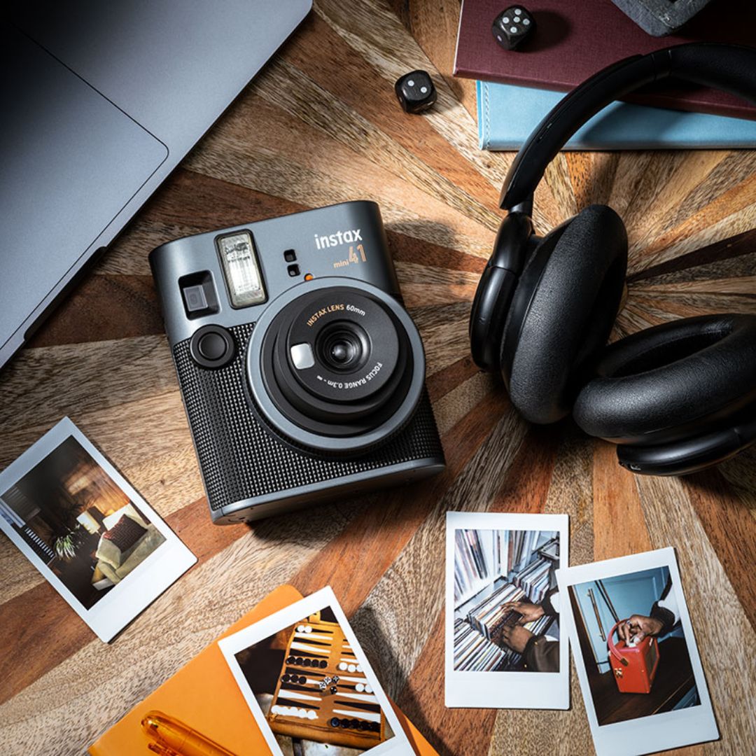 Fujifilm instax mini 41 Instant camera on a wooden surface with photos and headphones