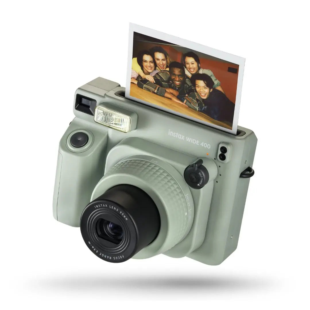 Close-up of the Instax Wide 400 in Sage Green showing the lens and wide-format film ejection slot.