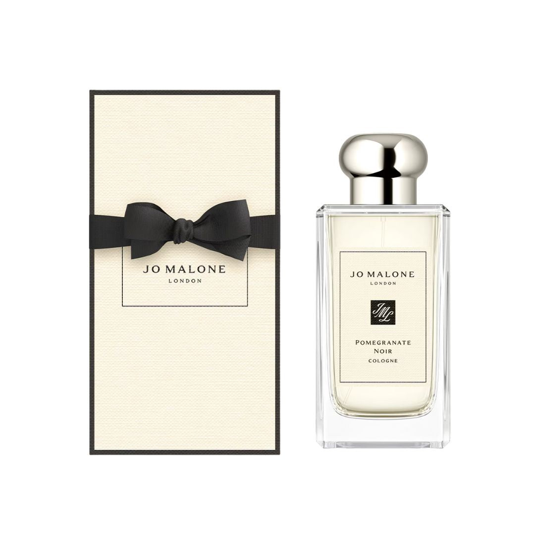 Jo Malone Pomegranate Noir Cologne 100ml, a classic transparent bottle with a silver cap and a minimalist label, suggesting a bold, fruity, and woody fragrance.