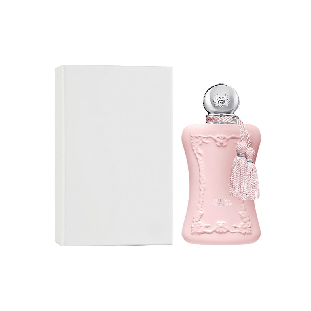 A pink decorative perfume bottle of Parfums de Marly Delina Exclusif EDP 75ml Tester with a silver cap and tassel, shown next to a plain white rectangular box on a white background.