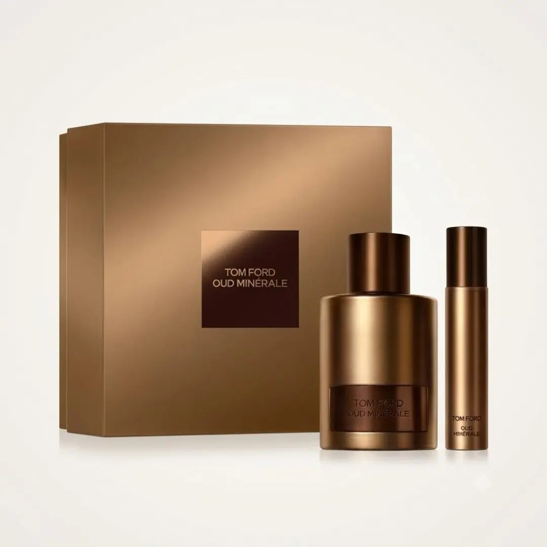 Tom Ford Oud Minérale fragrance set featuring a large metallic bronze bottle, a matching travel spray bottle, and a square metallic box with the brand name on a white background.