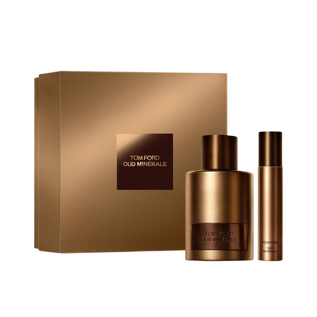 Tom Ford Oud Minérale fragrance set featuring a large metallic bronze bottle, a matching travel spray bottle, and a square metallic box with the brand name on a white background.