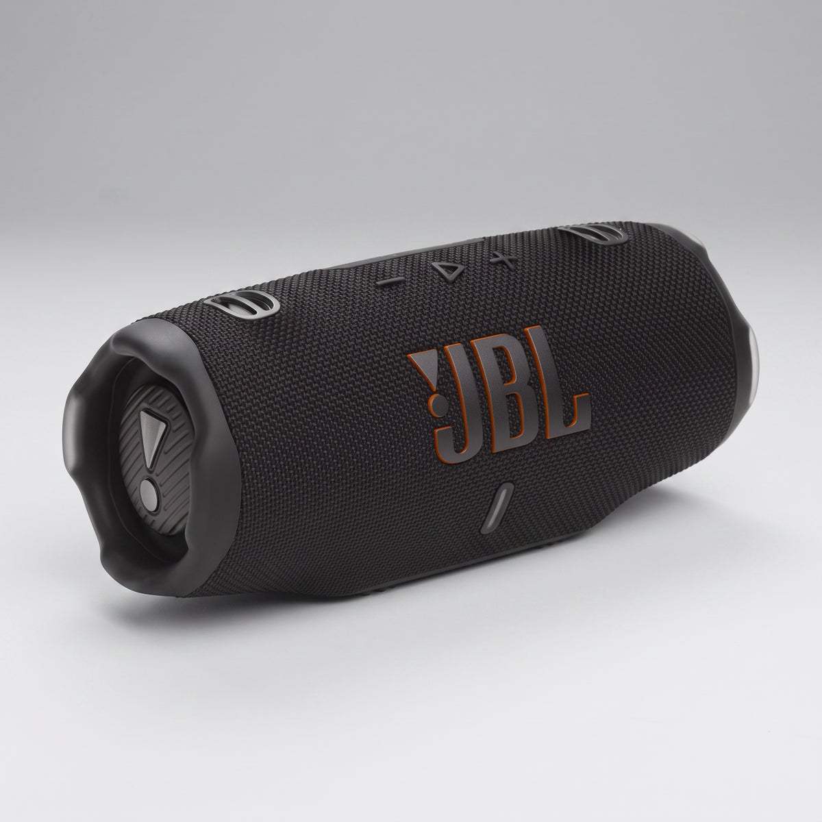 A JBL charge 6 portable Bluetooth speaker in matte black with a textured fabric cover and metallic orange logo, shown on a neutral gray background.