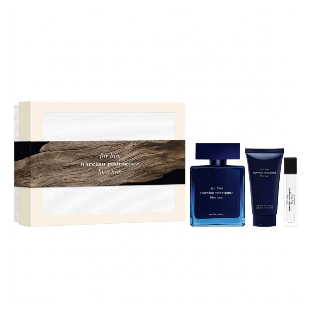 Narciso Rodriguez Bleu Noir EDP 100ml 3pc Gift Set gift set on a white background, featuring a cream-colored box with a dark wood-grain band, a blue rectangular perfume bottle, a matching blue body wash tube, and a small clear sample vial.