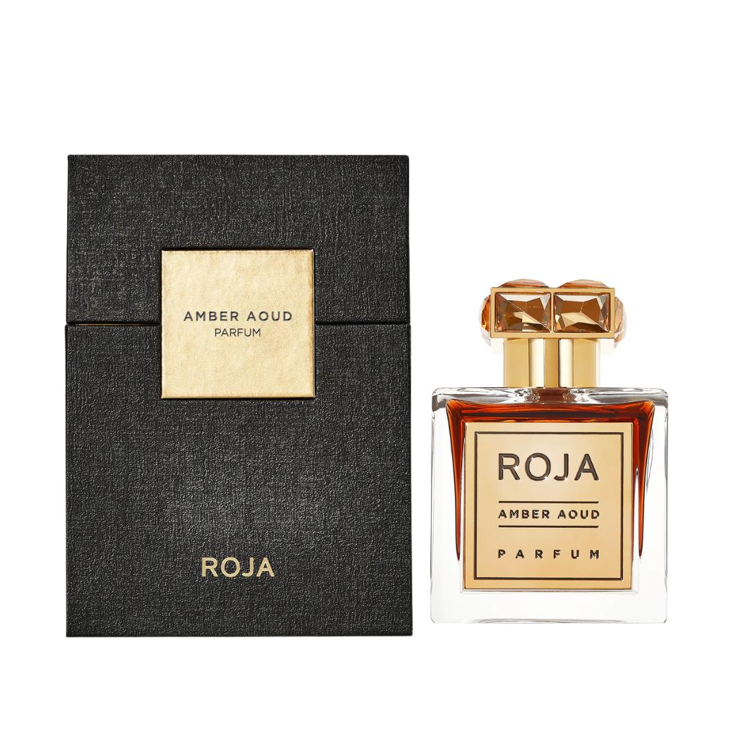 Roja Parfums Amber Aoud 100ml Parfum, a luxurious clear bottle with a gold plaque and gemstone cap, suggesting a rich, opulent, and intense unisex fragrance.