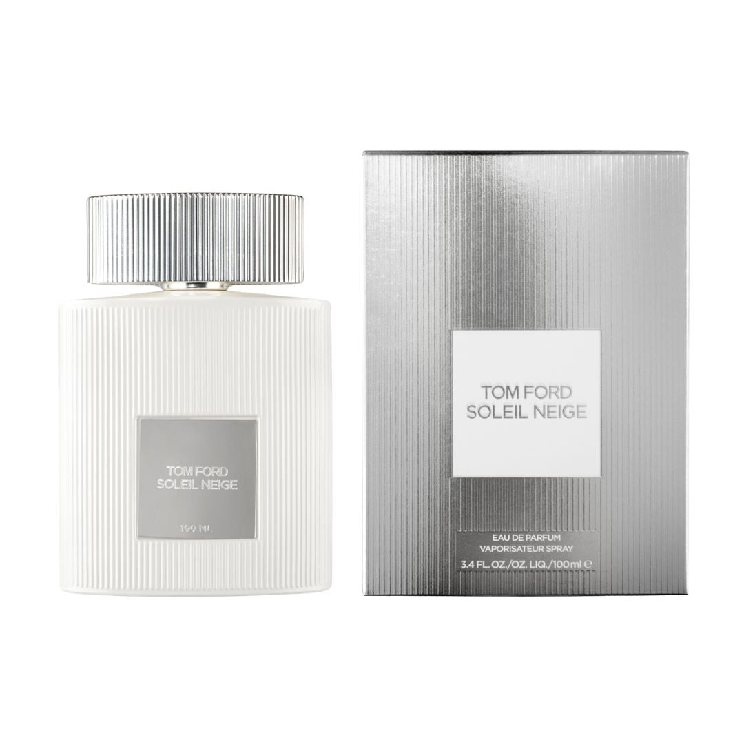 Tom Ford Soleil Neige Eau de Parfum bottle in white with a ribbed silver cap, shown next to its textured silver packaging box on a white background.