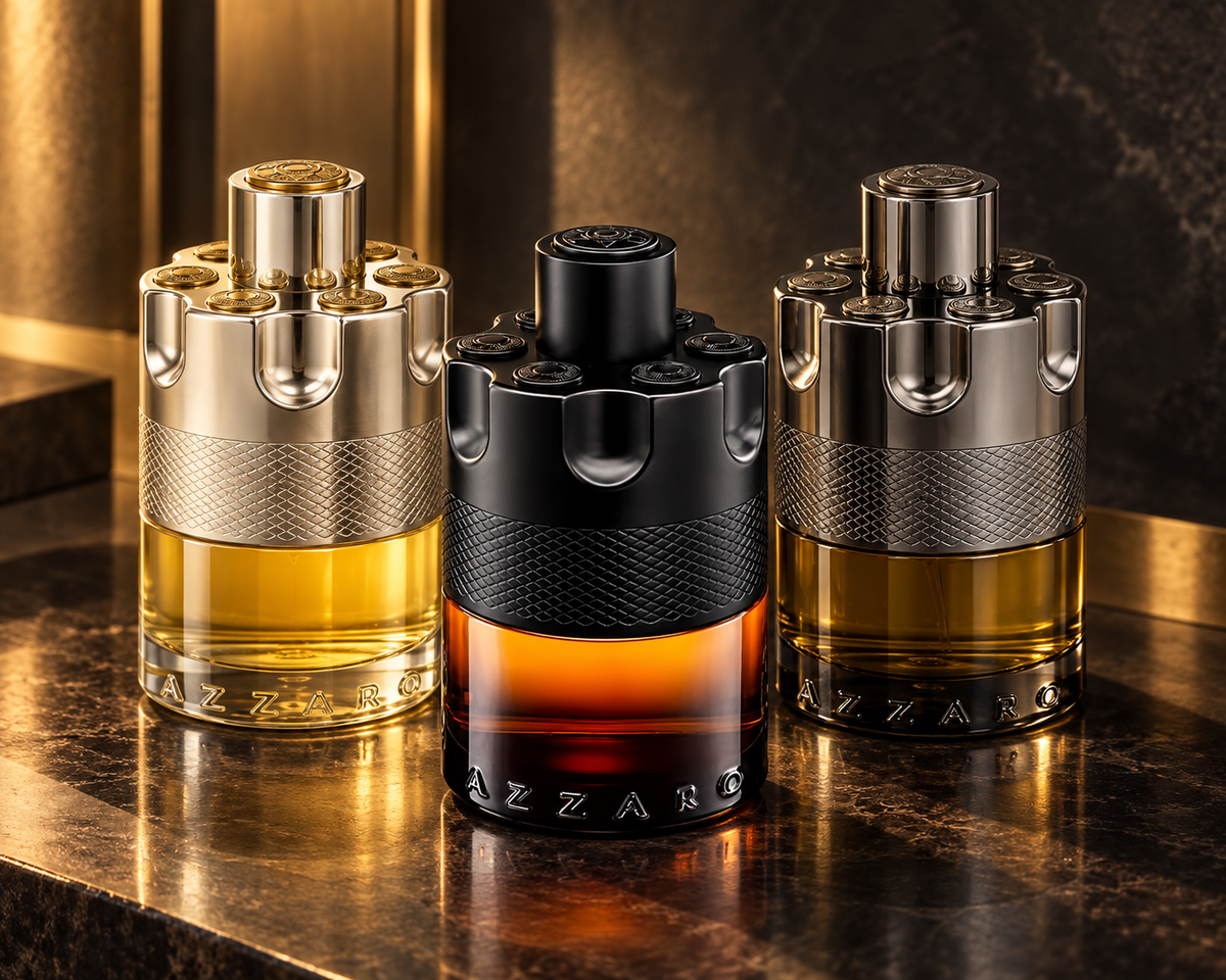 Azzaro Wanted, The Most Wanted Parfum and Wanted By Night bottles with smoked amber, warm brass and cinematic light.