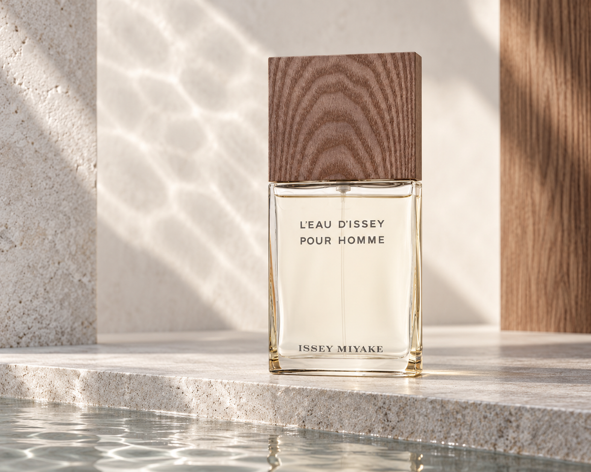 Issey Miyake L’Eau d’Issey Pour Homme Vétiver bottle with its natural wood cap beside pale stone and reflected water light.