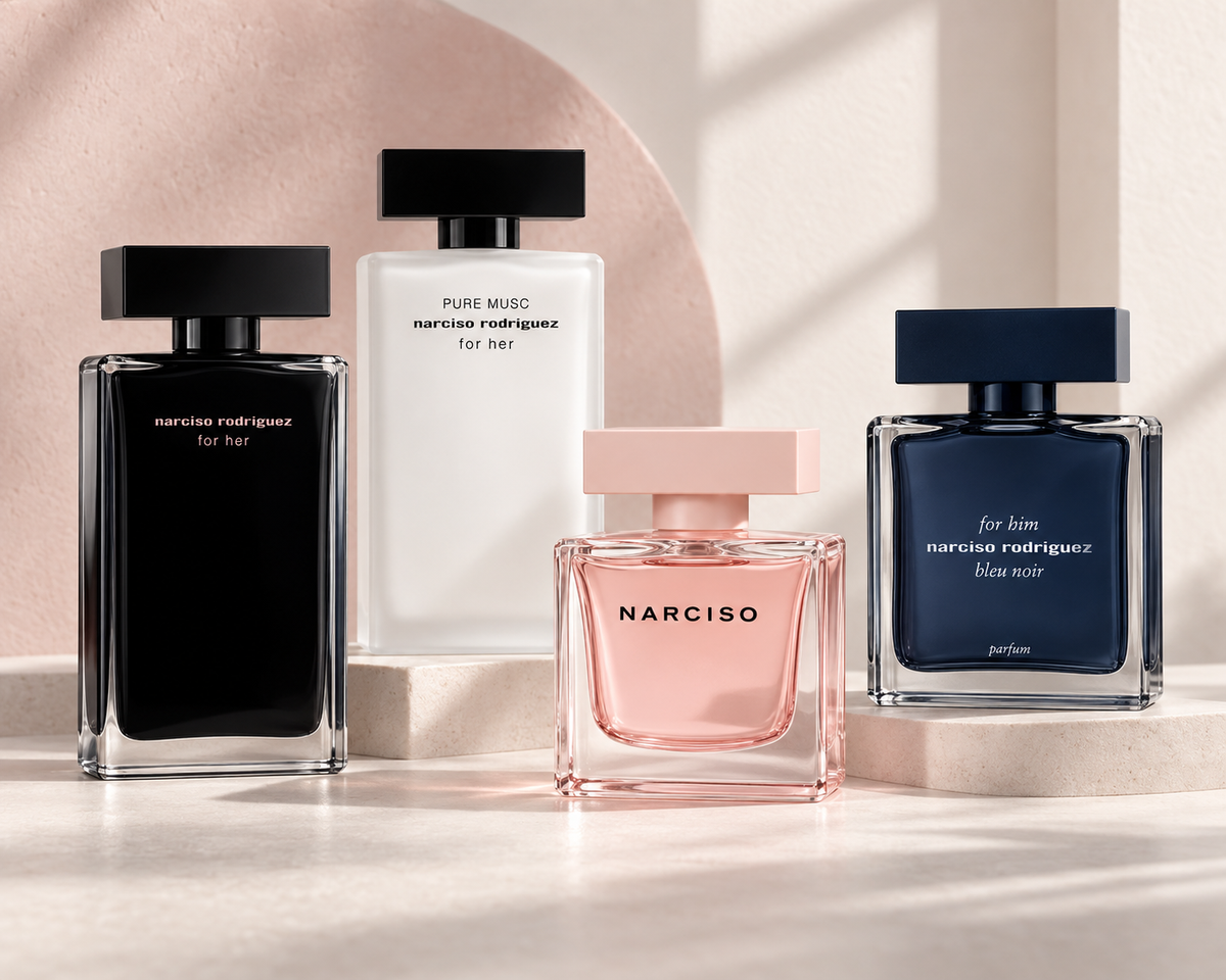 Narciso Rodriguez For Her, Pure Musc, Cristal and Bleu Noir Parfum bottles against soft ivory and powder-rose plaster.