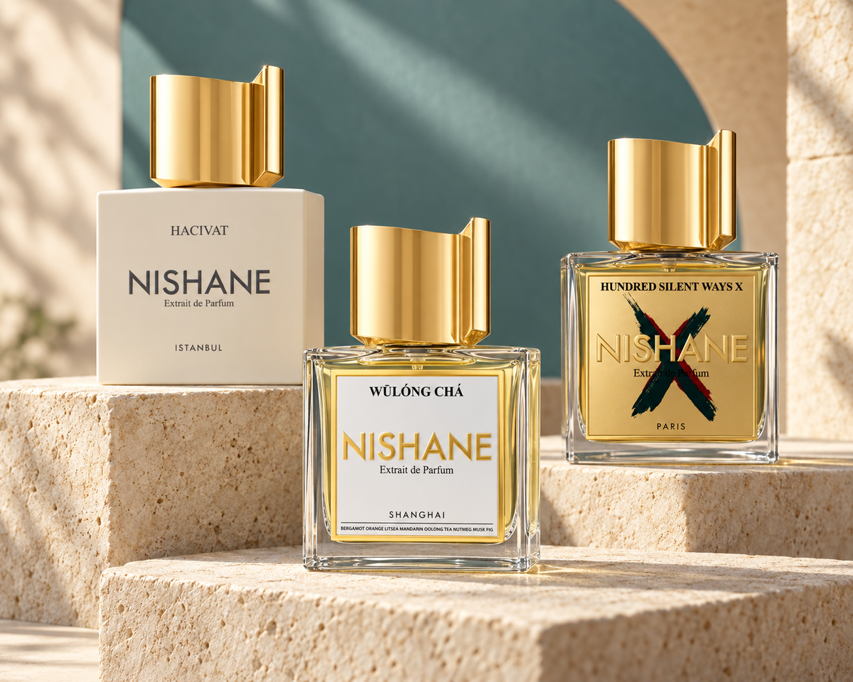Nishane Hacivat, Wulong Cha and Hundred Silent Ways X bottles on warm sandstone with muted teal.