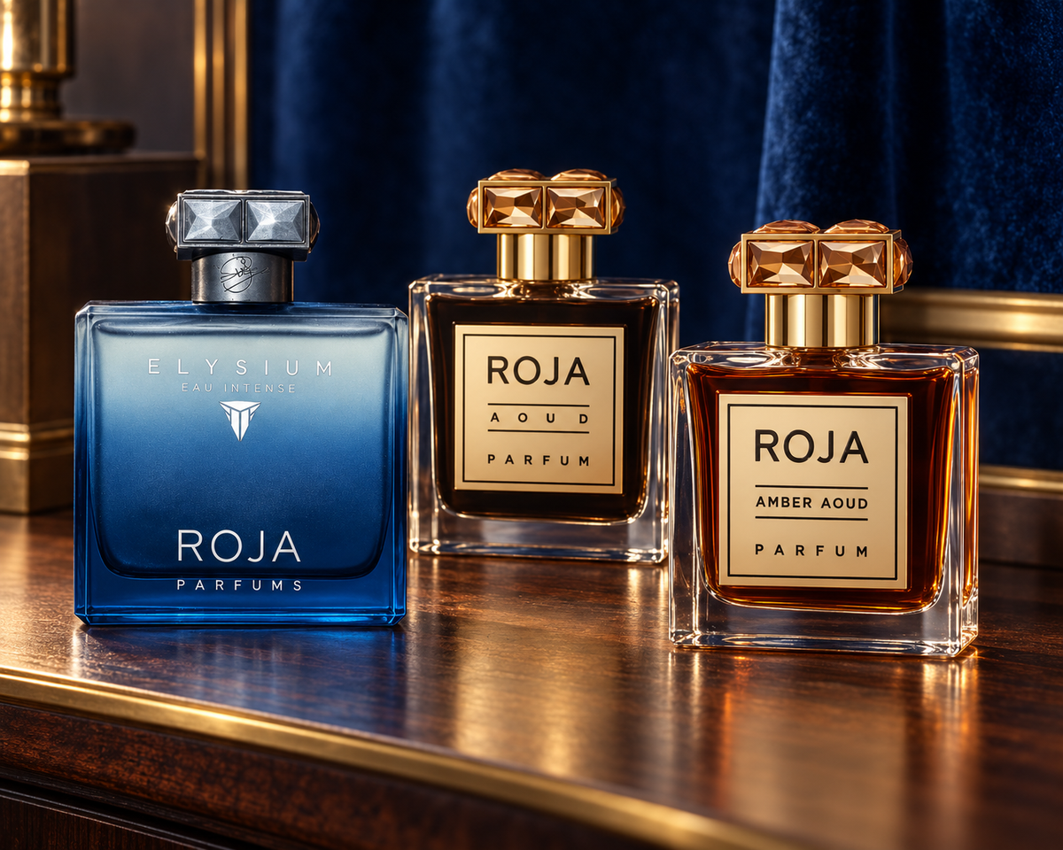 Roja Elysium Eau Intense, Aoud and Amber Aoud bottles with sapphire velvet, dark walnut and warm gold light.